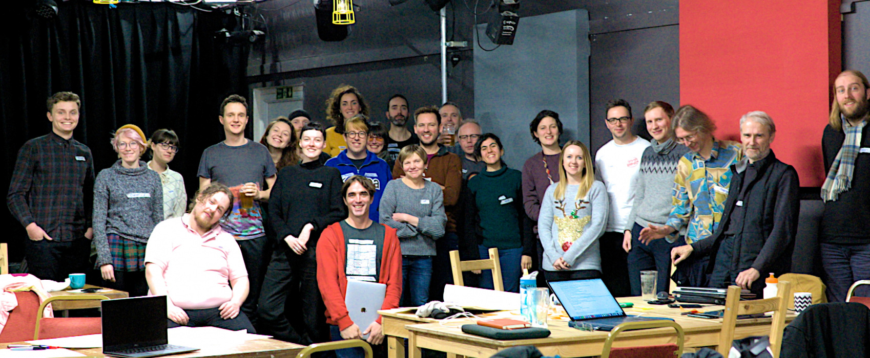 A picture of 60 people smiling in a large hall.